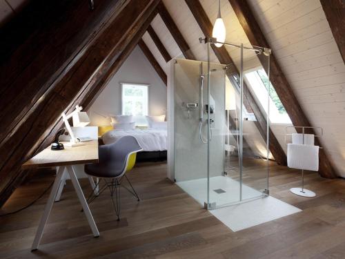 een slaapkamer met een douche, een bureau en een bed bij DORMERO Hotel Schwäbisch Hall in Schwäbisch Hall