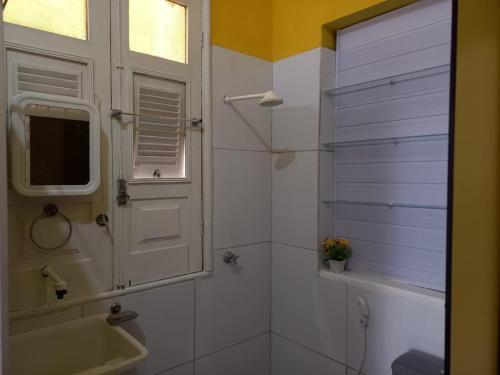 a bathroom with a sink and a shower with a window at Kitnet Mobiliada in São Luís