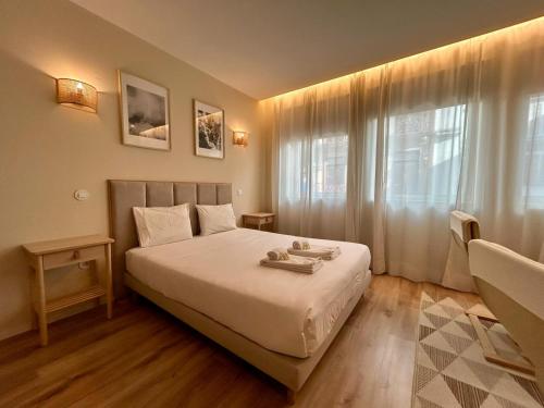 a bedroom with a bed and a large window at Lemago Porto Apartments - Bonjardim in Porto