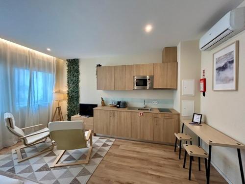 a kitchen with wooden cabinets and a table and chairs at Lemago Porto Apartments - Bonjardim in Porto