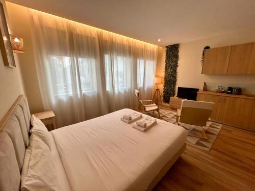 a bedroom with a bed with two towels on it at Lemago Porto Apartments - Bonjardim in Porto