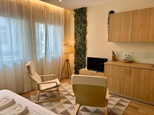 a room with a bed and a tv and a chair at Lemago Porto Apartments - Bonjardim in Porto