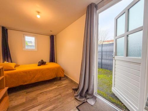 a bedroom with a bed and a large window at La Rose Urban avec Parking privé et Gare à 2 min in Nogent-le-Rotrou