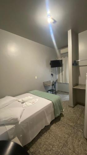 ein Schlafzimmer mit einem Bett und einer Deckenleuchte in der Unterkunft Hotel Amazonas in Cacoal