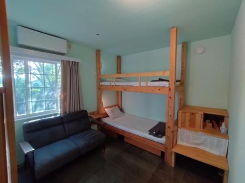 a living room with a bunk bed and a couch at Nemurupa Garden Hostel and Yoga near Narita Airport 15 min Late Check in in Narita