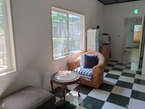 a living room with a chair and a table at Nemurupa Garden Hostel and Yoga near Narita Airport 15 min Shuttle in Narita