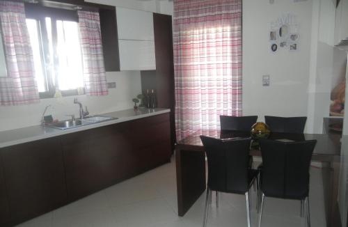 une cuisine avec une table, des chaises et un évier dans l'établissement Lamon, à Plakias