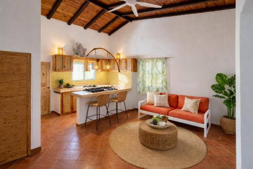 a kitchen and living room with a couch and a table at Casa los Mangos Private pool 150 m from the beach in Las Galeras