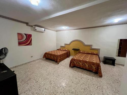 ein Schlafzimmer mit zwei Betten in einem Zimmer in der Unterkunft Hotel y Restaurant Real Plaza Jacona in Ciudad Valles