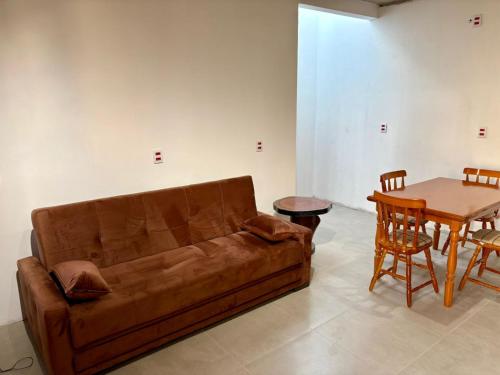 een woonkamer met een bank en een tafel bij Casa quadra-mar com piscina in Rio Grande