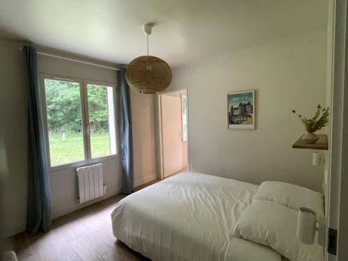 a bedroom with a white bed and a window at L'Échappée Boisée - côté Vallée in Chambon-sur-Cisse