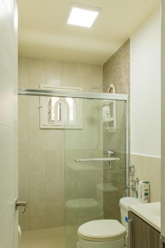 a bathroom with a toilet and a glass shower at Playa Dorada 3BR Home with Beach Club, pools, Garden with BBQ in ArraijÃ¡n