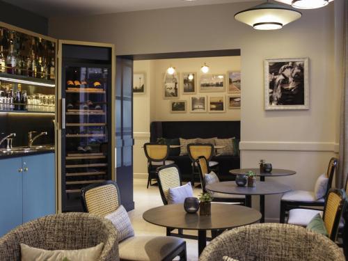 een restaurant met tafels en stoelen en een bar bij Mercure Paris Notre Dame Saint Germain des Prés in Parijs