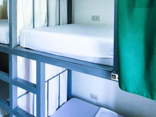 Green Turtle Backpackers Guesthouse, Puerto Princesa في مدينة بورتوبرنسس: سرير بطابقين في غرفة بجوار نافذة