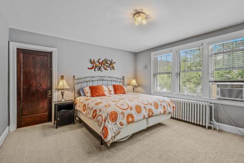een slaapkamer met een bed en twee ramen bij Aunt Bea's Bungalow - Pet Friendly - Hot Tub - Screen Porch - Wifi - Fenced Yard - King Bed - Town in Berkeley Springs