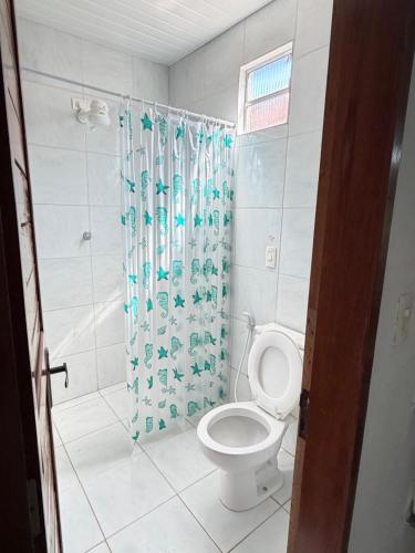 een badkamer met toilet en douchegordijn bij Pousada Maré in Ponta do Mel
