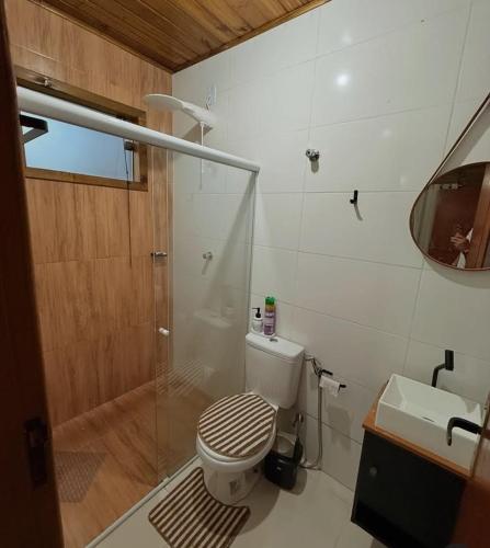 a bathroom with a toilet and a shower and a sink at Cabana Pouso Sereno in Domingos Martins