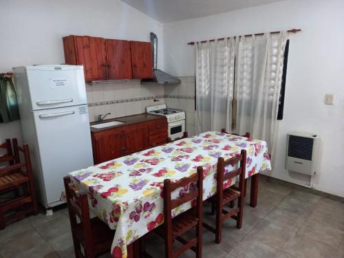 een keuken met een tafel met een bloemrijke tafelkleed bij Casa Doña Victoria in Villa Carlos Paz