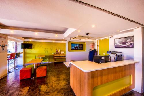 a man standing at a bar in a restaurant at ibis Budget - Campbelltown in Campbelltown