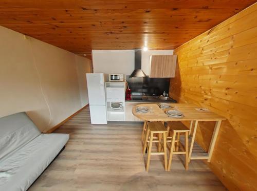 una piccola cucina con tavolo e frigorifero di Le Chitelet vue sur pistes a Xonrupt-Longemer