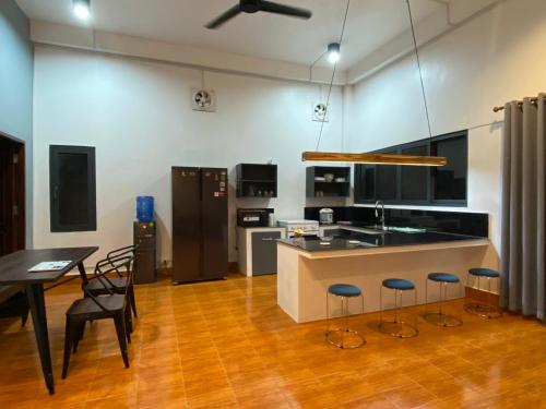 une cuisine avec un comptoir, une table et des chaises dans l'établissement Casa Primera, à Luang Prabang