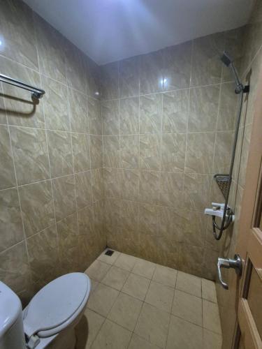 a bathroom with a toilet and a shower at Halim Living in Sukarami