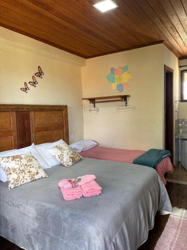 a bedroom with two beds with pink towels on them at Pousada Sossego in Lavras Novas