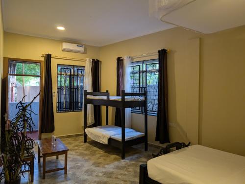 ein Zimmer mit einem Etagenbett, einem Bett und Fenstern in der Unterkunft Kijiji Beach Resort in Daressalam