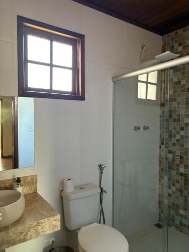 a bathroom with a toilet and a sink and a shower at Pousada Sossego in Lavras Novas