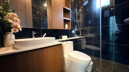a bathroom with a white toilet and a sink at PNT VILLA PATTAYa in Nong Prue