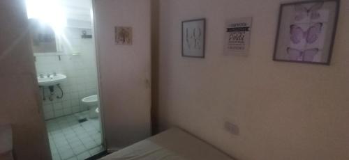 een badkamer met een bed, een wastafel en een spiegel bij Hostel San Telmo in Buenos Aires