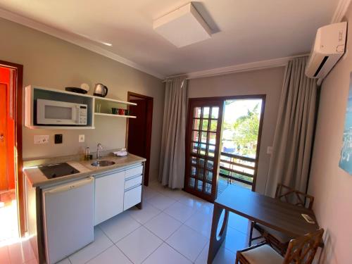 een keuken met een tafel en een magnetron bij AP Beira da Lagoa da Conceição in Florianópolis
