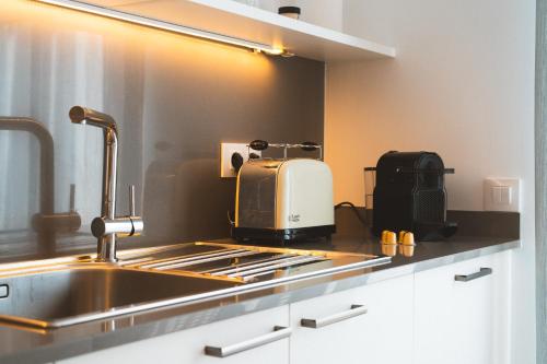 eine Küche mit einer Spüle und einem Toaster auf der Theke in der Unterkunft Casa súper acollidora completament reformada in Saldet