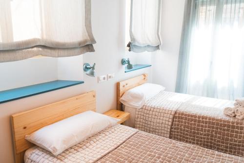 ein Schlafzimmer mit zwei Betten und einem Fenster in der Unterkunft Casa súper acollidora completament reformada in Saldet