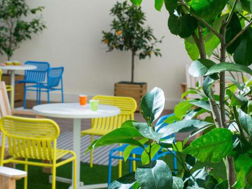 een kamer met gele stoelen, tafels en planten bij Ibis Styles Nice Centre Gare in Nice