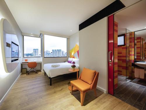 新加坡Ibis Styles Singapore On Macpherson的一间卧室，配有一张床、一张桌子和一把椅子