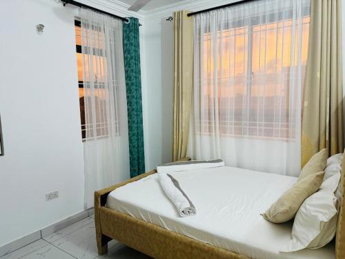 a bed in a room with a window at Casses Apartments in Mombasa