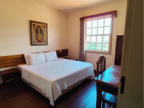 En eller flere senge i et værelse på Pousada Geraes - Sua casa longe de casa