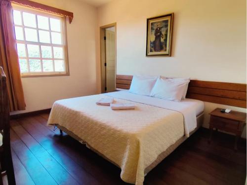 a bedroom with a bed with two towels on it at Pousada Geraes in Ouro Preto