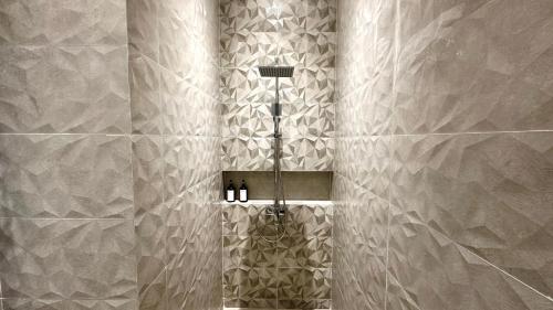 ein Bad mit einer Dusche mit silbernen Fliesen in der Unterkunft Davion House near IKEA KBP by YourHome in Simpar