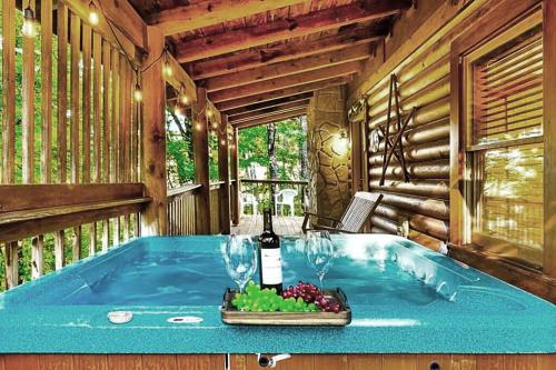 een kamer met een bad, een fles wijn en druiven bij Wonderland Cabin in Sevierville