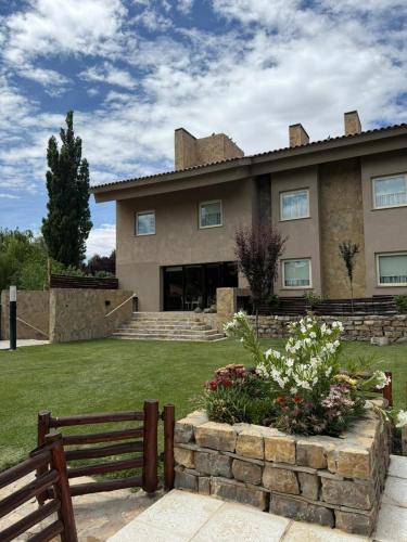 a house with a fence in front of a yard at Terra Malal in Chos Malal
