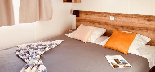 een slaapkamer met een bed met een houten hoofdeinde bij La Vetta Village Vacances Camping in Porto-Vecchio