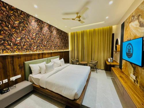 a bedroom with a bed and a flat screen tv at The Sterling Resort in Bhawānīgarh
