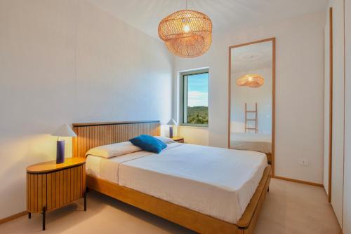 a bedroom with a bed and a large window at Casa Ponente in Porto Santo Stefano