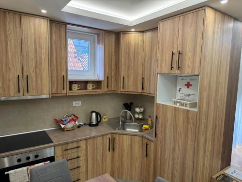 a kitchen with wooden cabinets and a sink at Primavera apartments Banja Koviljaca in Banja Koviljača