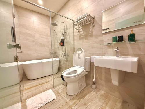 a bathroom with a toilet and a sink and a shower at 櫻花樹夏民宿 in Zhunan