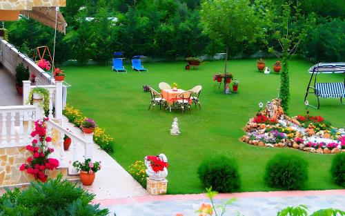 a garden with a table and chairs on a lawn at Relax pozar in Kato Loutraki