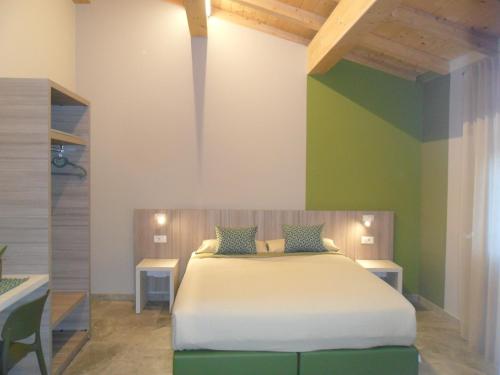 a bedroom with a large bed with two tables at Carme31 Sirmione in San Martino della Battaglia