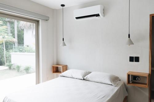 een witte slaapkamer met een bed en een raam bij Gaia Casa de Mar in El Bobo